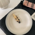 Elegant tortoise shell acetate hair clip with golden metal base on a white ceramic plate - Light Tortoiseshell