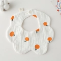 Detail view of 100% cotton gauze baby bib with orange patterns and snap button - Gauze Flower Scarf - White Background With Yellow Orange