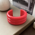 Close-up of a three-layer red resin open cuff bracelet on a minimalist lifestyle setting - 3-Layer Glossy Red / Red