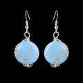 Macro shot of handmade tree of life wire-wrapped earrings with blue crystal stones - Opal