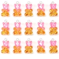 Macro shot of 15 pieces of sparkling resin gummy bear charms with pink glitter for DIY jewelry - Pink Yellow Glitter Bear