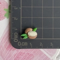 Vista dettagliata delle dimensioni del mini ciondolo a cocco su scala graduata in cm - Mezza Noce di Cocco con Foglia Verde