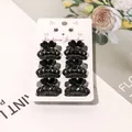Set of six small black glossy plastic hair claws on a fashion jewelry display card - Solid Black Pumpkin