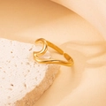 Adjustable golden wave ring in titanium steel displayed on a textured white stone base - Dynamic Wave - Gold