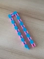 Blue and pink wacky tracks fidget toy made of 24-link plastic on light wood background - Pale Blue