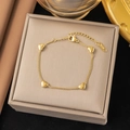 Minimalist 18K gold-plated bracelet with four polished heart charms on a jewelry box - Four Hearts Bracelet / Gold
