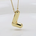 Macro detail of glossy gold puffed balloon letter L pendant with mirror-like metallic finish - Letter L (Necklace)