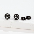 Macro detail of black spiral twist stud earrings in matte stainless steel on white stone - Geometric Spiral Black