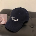 Detailed close-up of a navy blue baseball cap featuring white Nashville embroidery - Yellow