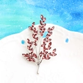 Silver leaf brooch with dark red crystals displayed on a white ceramic plate - Silver and Wine Red