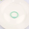 Mint green elastic hair tie for kids with cylindrical connector on white plate - Green