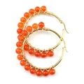 Detailed macro of gold wire wrapped hoop earrings with orange carnelian stone beads - Red Gold + Agate