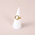 Minimalistische gouden ring met ovale witte steen op een witte kegelvormige standaard - Wit