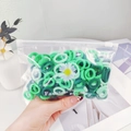 Green mixed elastic hair ties set in a floral zip bag held by hand for kids and babies - Green Daisy Bag