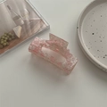Detail van grote roze gemarmerde acetaat haarklem op een wit minimalistisch keramisch dienblad - Kersenbloesem Roze