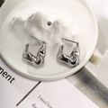 Detailed macro shot of silver fluid lava earrings on a white porcelain mountain tray - Style E-Silver Lava Fluid Earrings