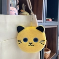 Detail of yellow plush cat coin purse with metal zipper hanging on a canvas bag - Approx. 10cm / Yellow