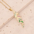 Close-up of golden feather pendant with colorful enamel and zircon on beige stone - Colorful Feathers