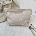 Détail de la trousse à maquillage rose clair avec broderies florales 3D et étiquette - Rose