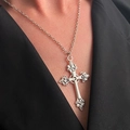 Zilveren vintage kruisketting met lelie-gravures gedragen op een zwarte blazer - Antiek Zilver (A-69)