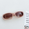 Close-up of pink oval sunglasses with gradient brown lenses on white texture - Orange Pink