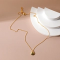 Close-up of a 18K gold-plated necklace featuring a round green zircon pendant on steps - August Peridot Green Zirconia