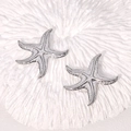 Starfish ocean style stainless steel stud earrings in silver on white coral background - Steel