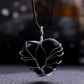 Macro detail of Tree of Life heart pendant with silver wire wrap on black obsidian stone - Obsidian
