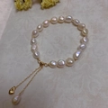 Detail of baroque pearl bracelet with gold beads and heart charm on neutral background - Baroque Pearl Heart Charm Style (SL7-4)