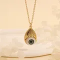 Detail shot of a teardrop Evil Eye pendant in 18K gold plating with green eye inlay - Green Drop-C4
