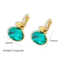 Macro shot of 16mm gold titanium hoop earrings with green oval crystal accents - Lake Blue