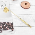Golden stainless steel candle snuffer with a bell head on a rustic white wood background - Gold Candle Snuffer Bell