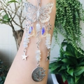 Detailed suncatcher with silver butterfly, crystals and moon charms in natural light - White Moonstone