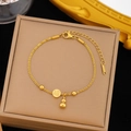 Golden stainless steel bracelet featuring gourd and lucky Fu character charms on a jewelry box - Gold Stainless Steel Fu Gourd Bracelet (SLE228)