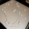 Detail of multi-layer silver chain with irregular white baroque pearls on a beige surface - Irregular Pearl Spliced Silver Chain Necklace