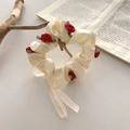 Beiger Satin-Haargummi mit 3D-Rosen und langen Bändern im Retro-Stil auf Buch - Gebrochenes Weiß