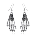 Détail de boucles d'oreilles main de squelette gothique argentées sur fond blanc - Main Squelette