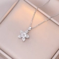 Elegant rotating silver flower necklace with sparkling zircon petals on jewelry box - X1465 Steel Rotating Flower
