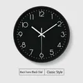 Minimalist round wall clock with a black dial, white numerals and matching black frame - Black Dial Black Frame