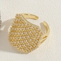 Close-up of golden geometric open ring featuring a sparkling full pavé zircon setting - Round Zircon Ring