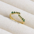Macro shot of V-shaped gold ring with graduated emerald green zircons on textured fabric - V-Shape Arrangement Green Gemstones (款式9)