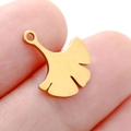 Golden ginkgo leaf shaped stainless steel pendant shown on finger for scale - DY745 Ginkgo Leaf / Gold