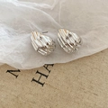 Detailed view of silver wave-patterned earrings on rustic natural fabric background - Wavy Shell Style (HE27803) / Silver
