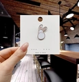 Spilla smaltata a forma di coniglio bianco su scheda con sfondo bokeh caldo e accogliente - Coniglio con Occhi Chiusi