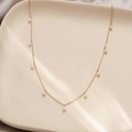 18K gold plated stainless steel necklace with delicate white pearls on ceramic tray - Pearl Necklace