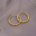 Elegant gold twisted hoop earrings with woven texture on a smooth grey silk background - Twist Texture Hoop / E-070---Gold
