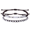 Detail of adjustable braided bead bracelets with marble stones and cylindrical charm - Two-Piece Set / Howlite