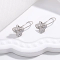 Elegante S925 Sterlingsilber-Ohrhänger in Blumenform auf einem weißen Schmuckständer - Stil B / Silber