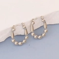 Macro detail of silver-toned stainless steel beaded hoop earrings with oval structure - Silver Style K7-76