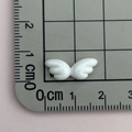 Nahaufnahme eines weißen Harzflügels auf einem Lineal zur Anzeige der 1,5 cm Breite - Weiße Engelsflügel